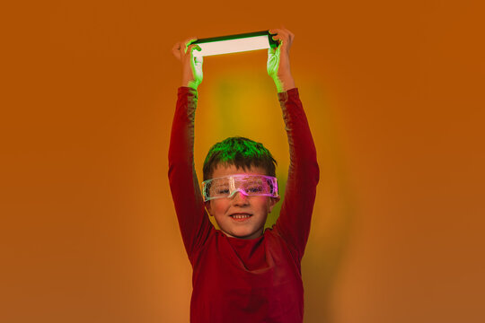 Kid with futuristic glasses raising glowing light wand