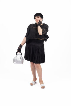 Woman in full length walking and holding small bag on white for professiona