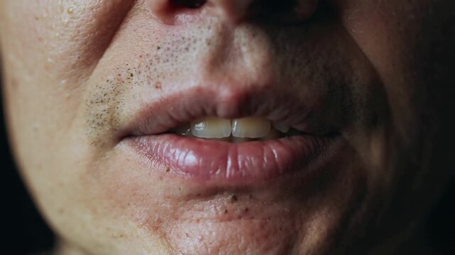 Exhaling senior man parting lips, opening mouth and articulating speech, showing teeth and stubble