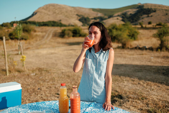 Woman enjoying gazpacho at summer picnic in countryside