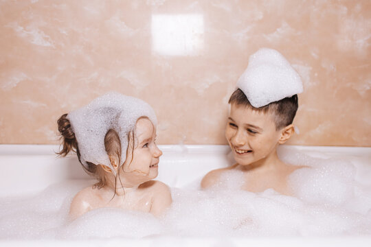 Brother and sister having fun in a foamy bubble bath