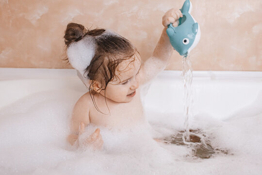 Cute toddler enjoying a playful bubble bath moment