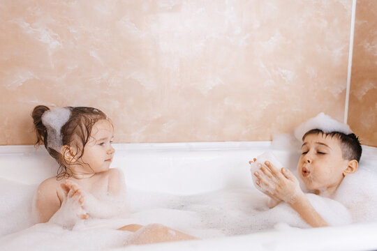 Siblings enjoying a playful bubble bath together