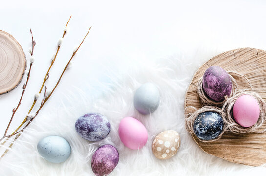 Pastel Easter egg composition on white fur flat lay