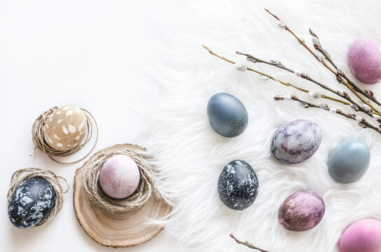 Pastel Easter egg composition on white fur flat lay