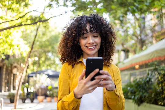 Hispanic woman with curly hair enjoys outdoor lifestyle