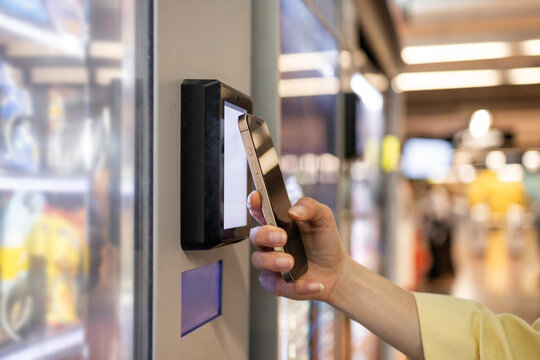 Woman making a smartphone payment at a vending machine