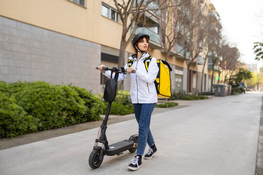 Woman food delivery rider with scooter and thermal backpack