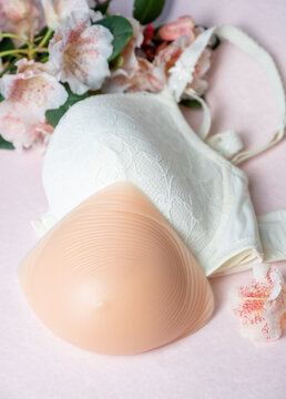Silicone external breast prosthesis after mastectomy recovery with bra and flowers
