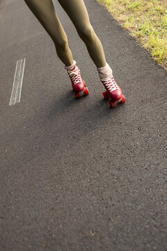Woman roller skating on paved path in outdoor setting