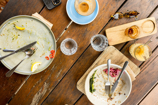 Rustic Outdoor Table With Empty Plates and Coffee Cups