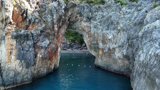 Cinematic view of Arcomagno natural rock arch and turquoise sea in Calabria, Italy
