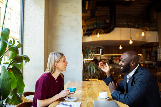 Two professionals meeting over coffee in modern cafe