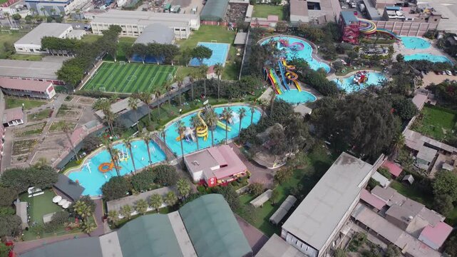 Aerial view Huachipa water park pools showing winding turquoise pools, twisting slides, sunbathers