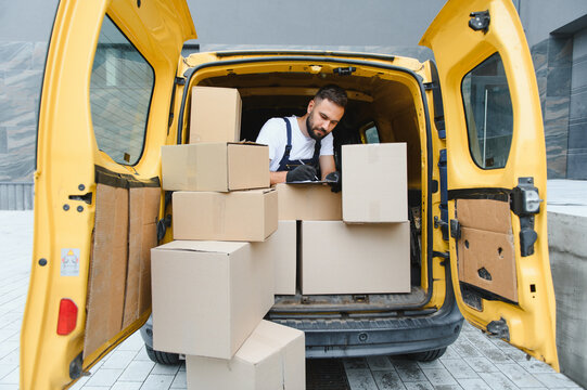 Deliveryman checking packages list in his yellow van