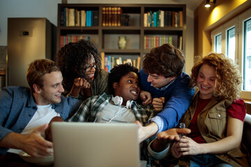 Fototapeta premium Diverse friends watching video on laptop at home