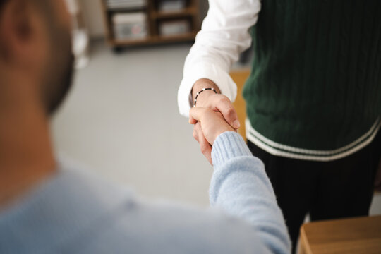 Two people shake hands, signifying agreement or a successful meeting.