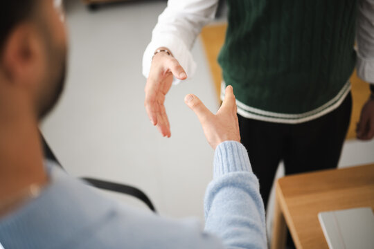 Two people are shaking hands, signifying agreement or a new beginning in a professional setting.