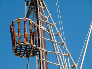 Crow’s nest on sailing ship mast against blue sky, maritime concept © Olena Netkach