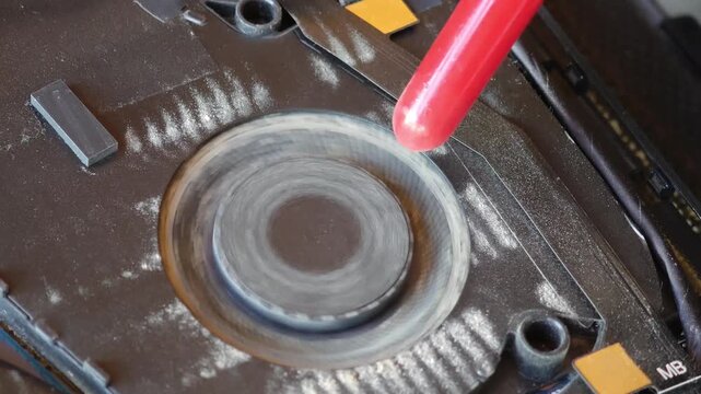 Macro view of a dirty laptop fan spinning. A technician is cleaning the CPU cooler from dust and dirt to prevent overheating
