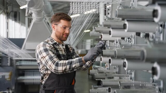 Factory worker operating a textile loom machine