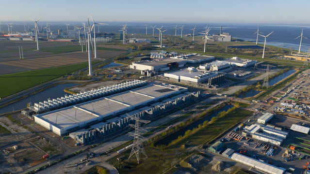 Aerial view of the Google Data Center surrounded by wind turbines and industrial infrastructure in Eemshaven, Groningen, Netherlands.