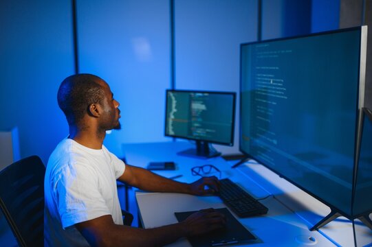 Portrait of african american male programmer in office at night