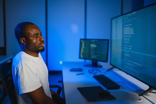 Portrait of african american male programmer in office at night
