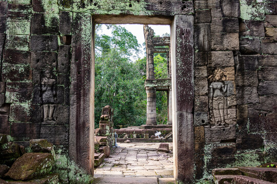 Stone gateway with Devata carvings and view of the two-story pavilion, Preah Khan