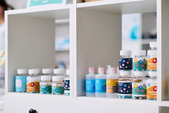 Close up of vitamin supplements and antiseptic gel bottles standing on pharmacy shelf, presenting healthcare retail and wellness products. Ideal for pharmacy marketing, immunity campaigns