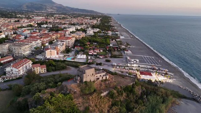 Horizontal aerial left side view of Torre Talao tower and Tyrrhenian sea coast in Scalea, Italy