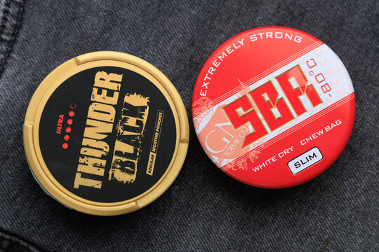 KYIV, UKRAINE - 03 MAY, 2026: Usage of snus and nicotine pouches on a denim background during a casual moment in daily life