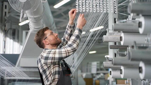 Factory worker adjusting polypropylene thread production machine