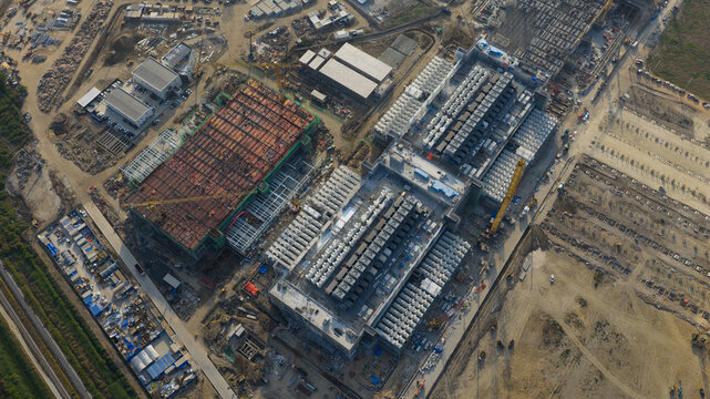 Aerial view of the Bridge Data Center under construction with industrial buildings and cooling units in Khlong Tamru, Chon Buri, Thailand.