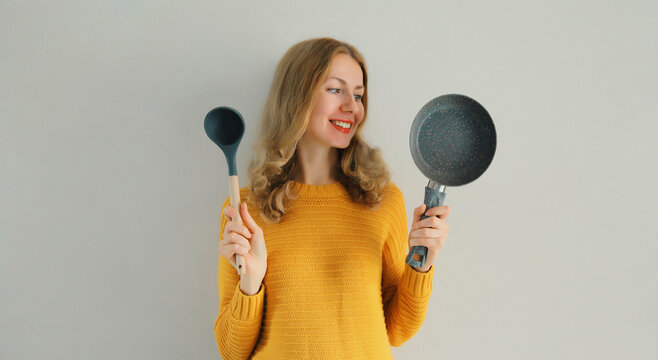 Cooking mood, portrait of happy smiling young woman housewife with empty frying pan