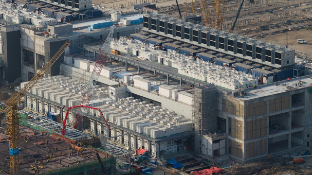 Aerial view of Bridge Data Center under construction with cooling units and cranes in Khlong Tamru, Chon Buri, Thailand.