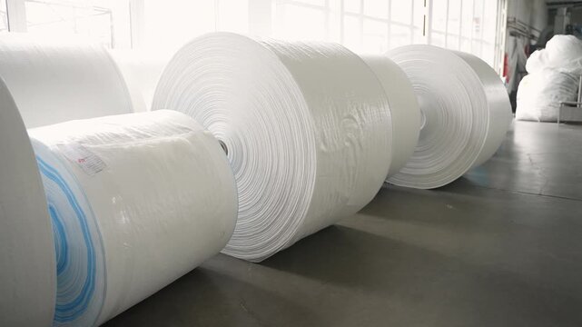 Polypropylene fabric rolls in a production factory warehouse