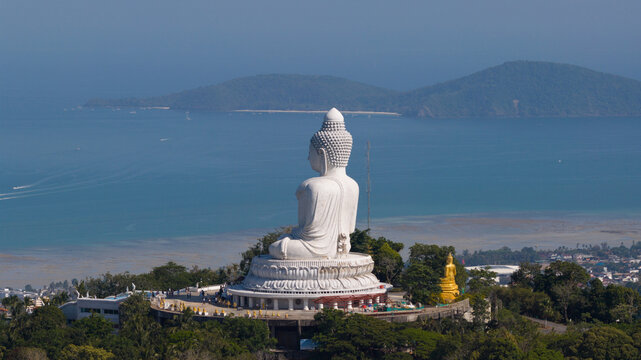 Aerial view of Big Buddha Phuket white marble statue on Nakkerd Hill overlooking the turquoise sea and distant islands with people on the observation deck Karon, Phuket, Thailand.