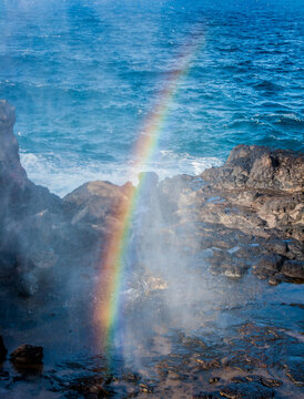 A rainbow forms in the mist from the Nakalele blow hole on Maui Hawaii