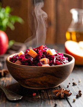 A bowl of braised red cabbage with apples and cloves, steam rising gently in the soft light of a dining room.