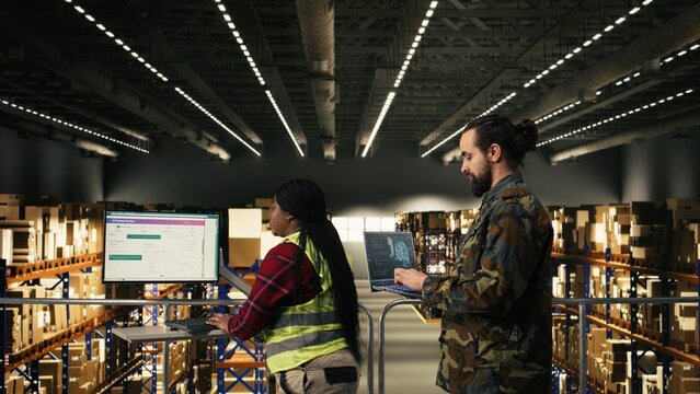 Army soldier using AI-powered tools in logistics hub at military base, monitoring artificial intelligence interface on laptop. Machine learning and neural networks supporting tactical operations.