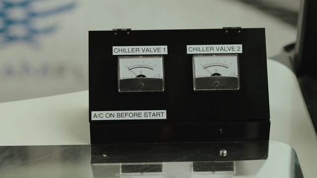 Close up of analog meters labeled chiller valves on industrial control system