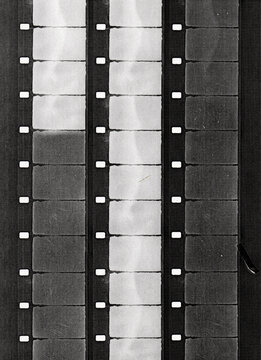 Several vertical 16mm film strips printed on paper with vintage analog cinema texture and monochrome print effect.