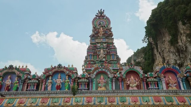 Detailed view of colorful Hindu temple facade with sculpted deities at Batu Caves Malaysia.