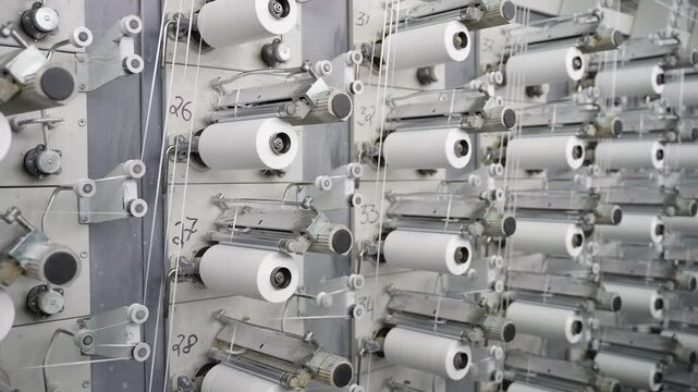 Industrial textile machine weaving white synthetic threads