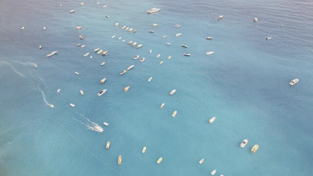 Aerial Drone View of Positano Bay Amalfi Coast Italy Many Boats Anchored Turquoise Mediterranean Sea Summer Travel Overhead Shot 4K HDR Cinematic Stock Footage
