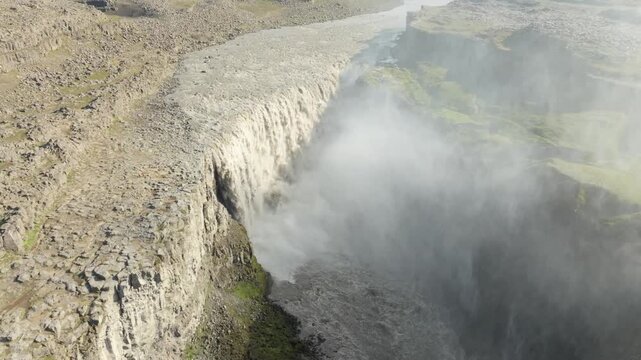 Aerial flight over the famous and powerfull Gullfoss waterfall on a summer evening in Iceland. The gigantic waterfall produces a lot of mist.