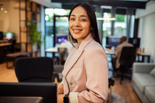 Confident businesswoman smiling in modern coworking office