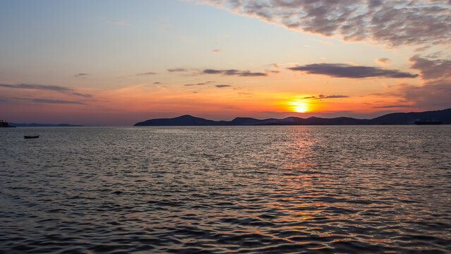 Sunset over tranquil Aegean Sea in Gulluk, Milas, Turkey, golden sun reflecting on the calm water