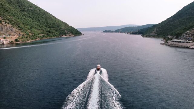 Caucasian individual expertly steering vessel amid scenic fjord scenery with calm waters and lush surroundings